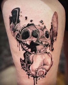 a black and white photo of a cartoon character tattoo on the thigh with paint splattered all over it