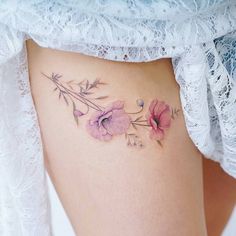 a close up of a woman's thigh with flowers on it