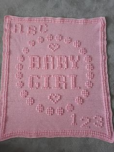 a pink crocheted blanket with the words happy birth on it