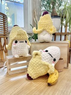 three crocheted stuffed animals sitting on top of a table next to a banana