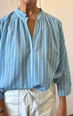 A favorite summer top in a white and chambray stripe, stand up button collar. This shirt really looks pulled together with pants, a blazer..It's lightweight and can work perfectly for work to beach mode.  Tuck it in or wear it out. Seen here on Model (a size 6)  Color:  chambray with white —  handwoven khadi  cotton — Cheap Chambray Tops For Spring, Summer Chambray Blouse, Affordable Summer Chambray Blouse, White Print Summer Shirt, Cheap Cotton Shirt For Brunch, Cheap Everyday Chambray Shirt, Affordable Chambray Button-up Tops, Cheap Chambray Tops With Button Closure, Affordable Cotton Shirt For Brunch