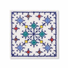 a cross stitch pattern on white paper with blue, yellow and red crosses in the center