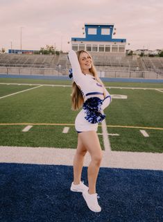 a cheerleader is posing on the football field