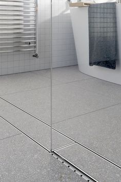 a bathroom with a white bath tub sitting next to a shower curtain and towel rack