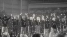 a group of people standing on top of a stage with their hands in the air