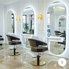 the interior of a salon with chairs and mirrors