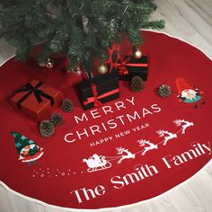 a christmas tree skirt with presents on the floor next to it and a merry christmas sign