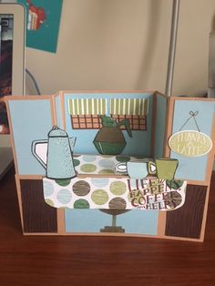 an open card with a teapot and cup on it