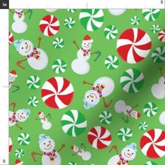 a green christmas wrapping paper with candy canes and snowmen on it's sides