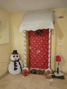 a snowman is standing in front of a door decorated with candy canes and decorations