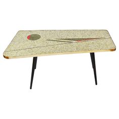 the table is made out of marble with black legs and a red dot on it