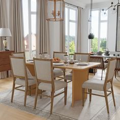 a dining room table and chairs in front of large windows