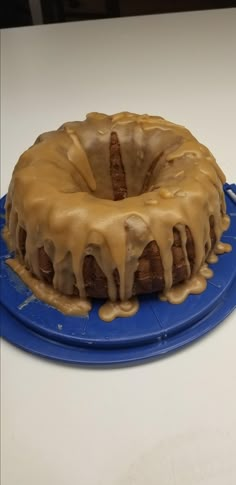 a bundt cake sitting on top of a blue plate covered in frosted icing