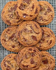 chocolate chip cookies stacked on top of each other in front of a wire cooling rack