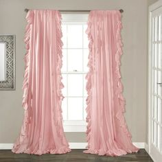 pink ruffled curtains hanging in front of a window