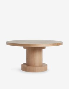 a round wooden table sitting on top of a white wall