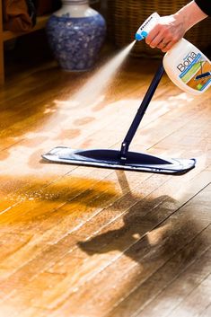 a person is using a spray mop on the floor