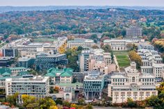 an aerial view of the city with many buildings and trees in autumn colors around it