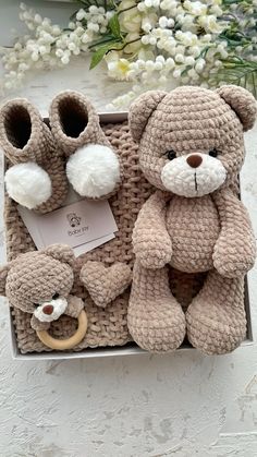 a crocheted teddy bear and its baby booties in a box