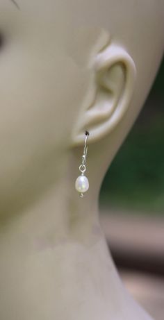 "White fresh water pearl sterling silver dangle earrings 5x7mm white fresh water pearls are wrapped in sterling silver dangling from budded sterling silver hooks. Measure 1 ¼\" long" Delicate White Pearl Earrings For Everyday, Simple Silver Pearl Drop Jewelry, Nickel-free Minimalist Pearl Earrings, Dainty Sterling Silver Pearl Earrings For Wedding, Pearl White Sterling Silver Pearl Earrings For Gift, Handmade Sterling Silver Pearl Earrings For Wedding, Dainty Nickel-free Pearl Earrings For Wedding, Pearl White Sterling Silver Earrings For Gift, Handmade Dainty Pearl Earrings