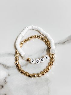 🤍Personalized jewelry is the best way to add a unique touch to your every day look. This birth year bracelet comes with a complimentary gold filler bracelet 🤩 🤍These custom birth year bracelets make the PERFECT birthday gift for her, mom, girlfriend, sister, friend, etc! 🤍Care: To maximize the life of this bracelet, do not expose it to water, lotion, soap or any liquids. Gold Beaded Bracelet For Birthday Gift, Gold Bracelet With Round Beads For Birthday Gift, Gold Beaded Bracelets For Birthday, White Stackable Stretch Bracelet For Birthday, White Beaded Jubilee Bracelet For Anniversary, Personalized Gold Beaded Bracelet For Birthday, Gold Bracelets With Letter Beads For Birthday Gift, Gold Stretch Bracelet With Round Beads For Birthday, Anniversary Gold Bracelets With Letter Beads