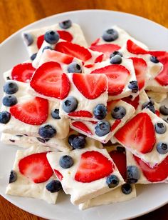 strawberries and blueberries are arranged on top of white chocolate barkle squares in the shape of hearts