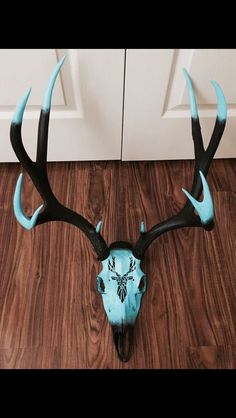 a deer's head with blue antlers is on the floor in front of a door