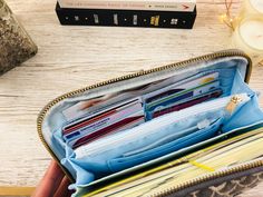 an open wallet sitting on top of a table next to a candle and some books