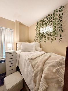 a bedroom with a bed, dresser and window covered in ivy leaves on the wall