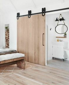 a bedroom with a bed, mirror and sliding barn door in it's center