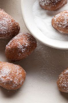 powdered sugar covered donuts in a bowl