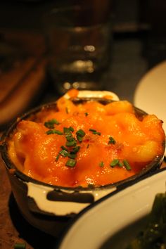 a bowl filled with macaroni and cheese on top of a table next to other dishes