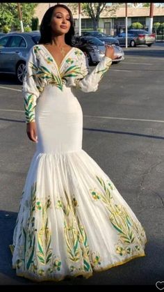 a woman in a white dress is standing in the middle of a parking lot