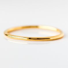 a gold wedding band on a white background