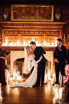 a bride and groom kissing in front of candles