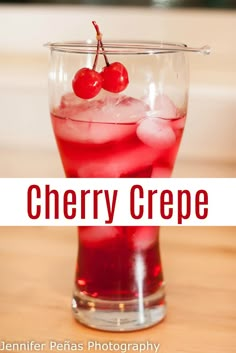 cherry crepe cocktail in a glass with ice and cherries on the rim