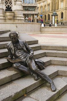 a bronze statue sitting on top of some steps