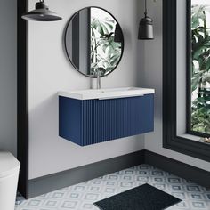 a bathroom with a sink and mirror next to a window in the wall, along with a rug on the floor