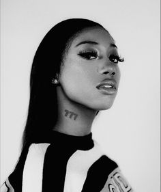 a black and white photo of a woman with tattoos on her neck