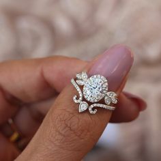 a woman's hand holding a diamond ring in her left hand, with the engagement band on it