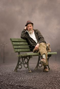 a man sitting on top of a green bench