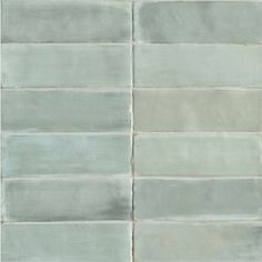 a white tile wall that has been painted in shades of blue and grey, as well as