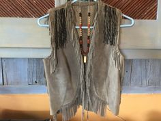 North Beach leather artisan made hand laced gray suede fringed beautiful shade of gray with Feather design on the back. Colorful period piece. 34" bust shoulder to hem 18". The artist that crafted this made Cher's iconic feather vest on the cover of People magazine. A real gem! Fall Festival Vest With Fringe, Bohemian Fringe Vest For Festivals, Brown Bohemian Vest With Fringe, Bohemian Brown Vest With Fringe, Brown Bohemian Fringe Vest, Bohemian Brown Fringe Vest, Bohemian Fringe Vest, Feather Vest, Faux Fur Handbag