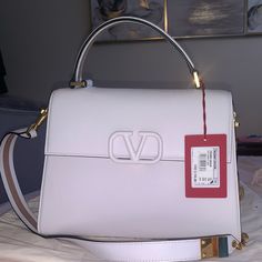 Brand New Authentic Valentino Tote Purchased From Saks. Designer White Square Bags, Designer White Square Bag, Elegant Satchel With Dust Bag For Errands, Elegant Square Satchel For Errands, White Satchel With Branded Hardware For Evening, Designer Satchel With Branded Hardware For Shopping, Designer Shoulder Bag With Branded Hardware For Errands, Designer White Satchel For Errands, Luxury Satchel With Branded Hardware For Errands