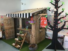 a child's play area with a tree, ladders and toys on the floor