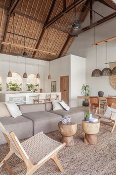 a living room filled with lots of furniture next to a wooden table and two chairs