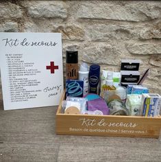 a wooden box filled with personal care items next to a sign that says kit de secours