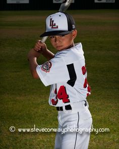 a young baseball player is getting ready to swing his bat at the ball while standing in the outfield