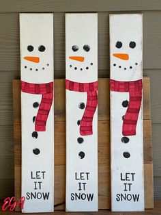 three snowmen painted on wooden boards with the words let it snow