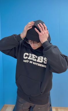 a person wearing a black hoodie with the word cbbs on it